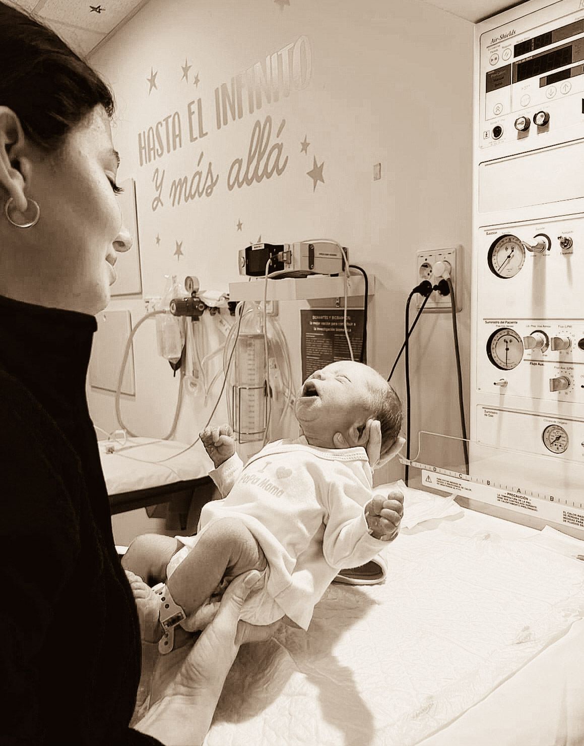 Foto ganadora Segundo concurso de fotografía donde una sanitaria tiene en sus manos a un recién nacido 