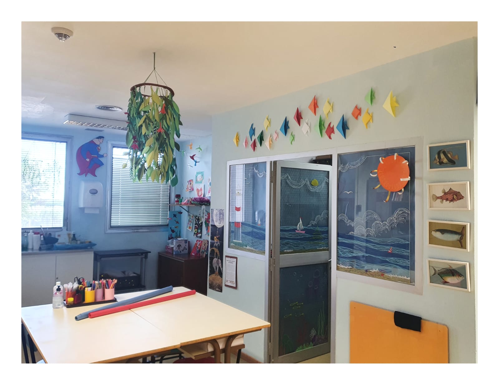 Se ve el aula exterior, ambientada con manualidades y imágenes marinas y el acceso al aula interior